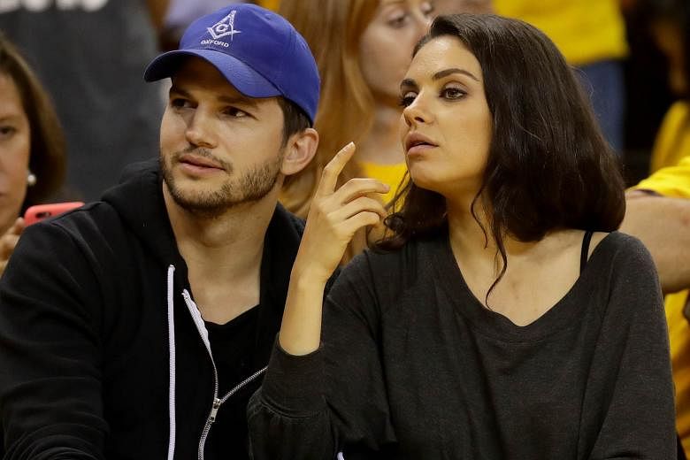 Actor Ashton Kutcher (above, with his wife, actress Mila Kunis) sports a cap while watching a basketball match in June in California.