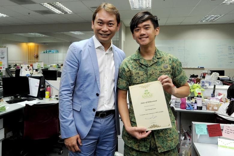 Sakae founder and chairman Mr Foo (at left) with marketing executive Mr Lee. Sakae staff who are NSmen receive vouchers for performing their NS duties well. Mr Lee received a certificate and an $80 voucher from the firm for getting a Silver in his IP