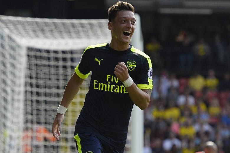 Mesut Ozil celebrates after scoring the third goal for Arsenal in their 3-1 win against Watford on Saturday, the Gunners' first victory of the Premier League season. Arsenal manager Arsene Wenger said: "I'm very happy that he scored because that's wh