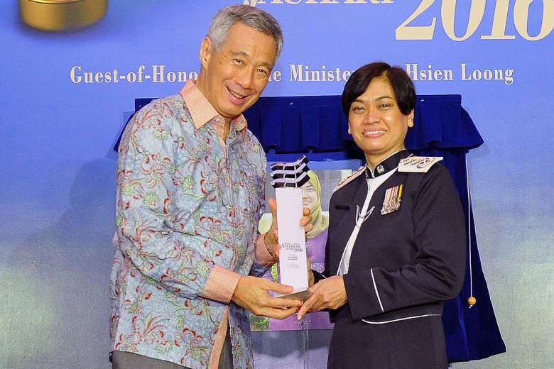 Madam Zuraidah receiving her award from PM Lee yesterday. Her accomplishments include being the first woman to become Senior Assistant Commissioner in the police force.