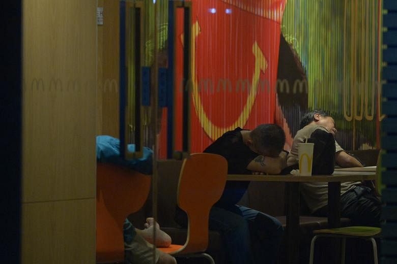Top and above: Patrons at a McDonald's outlet in the southern part of Singapore early yesterday morning. Some seek respite in the air- conditioned outlets while others find it hard to sleep at home.