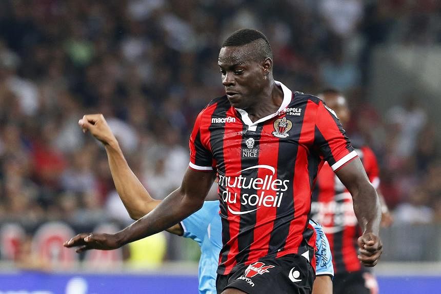 Nice striker Mario Balotelli evading the challenge of Marseille's William Vainqueur. The Italian opened his Ligue 1 account with a double to help his side to a 3-2 win, ending his year-long goal drought.