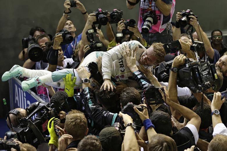 Mercedes driver Nico Rosberg celebrating with his team after winning the Singapore Grand Prix at the Marina Bay Street Circuit. It was the German's third race win in a row.