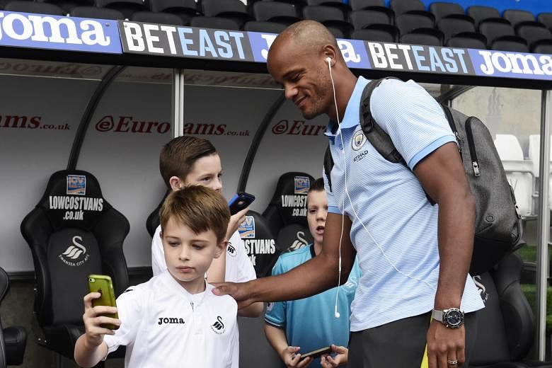 Manchester City's Vincent Kompany engaging young Swansea fans before their Premier League game on Saturday. His latest spell on the sidelines came when he was hurt during the two sides' League Cup tie in midweek.
