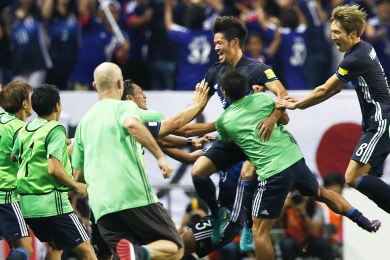 Japan midfielder Hotaru Yamaguchi (third from right) celebrates with his team-mates, including Genki Haraguchi (extreme right), after scoring a late winner during their World Cup qualifier against Iraq.