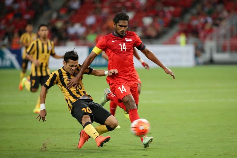 Hariss Harun being challenged by Malaysia's Azrif Nasrulhaq during last Friday's 0-0 draw. Hong Kong should prove to be a tougher proposition tonight.