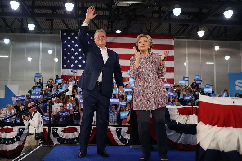 Mr Gore with Mrs Clinton at the Miami Dade College on Tuesday. He vouched for Mrs Clinton's credentials on increasing the use of solar power and other renewable energy.