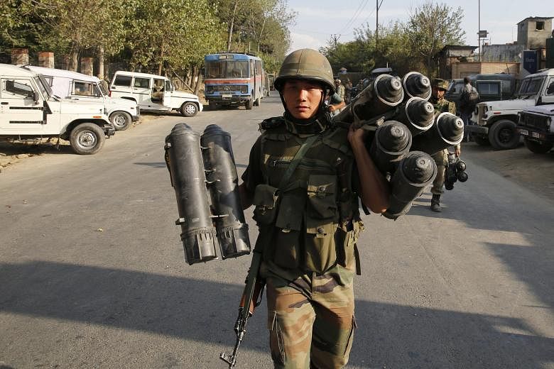 Indian army soldiers carrying ammunition yesterday as they left the site of a three-day gunfight at the Entrepreneurship Development Institute (EDI) in Srinagar, the summer capital of Indian Kashmir. Two militants were killed and an Indian army soldi