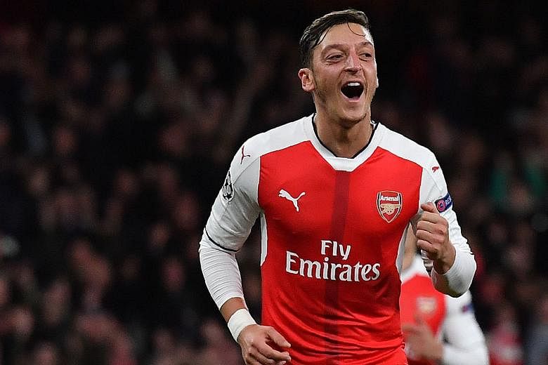 Midfielder Mesut Ozil celebrates scoring Arsenal's sixth goal during their Champions League Group A clash against Ludogorets Razgrad at The Emirates Stadium. His close-range volley in the 87th minute completed his hat-trick - the first treble of his 