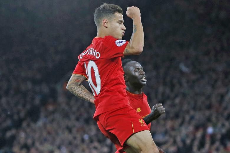 Brazilian Philippe Coutinho celebrating scoring Liverpool's second goal with Senegalese Sadio Mane, who had opened accounts. Gareth McAuley reduced arrears but the Reds hung on for full points, to go second behind Arsenal on goal difference ahead of 