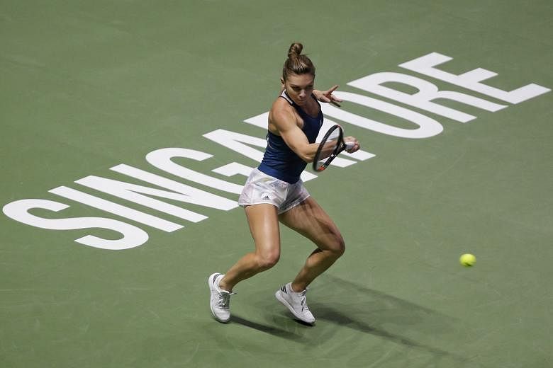 Simona Halep of Romania hitting a forehand against American Madison Keys during their opening women's singles group match at the WTA Finals at the Singapore Indoor Stadium. Halep sent the balls high and deep to counter Keys' flat, angled shots.