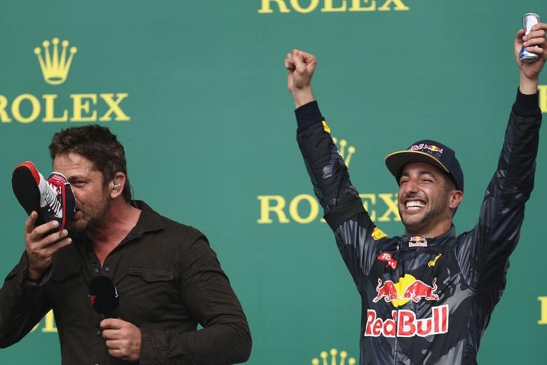 Scottish actor Gerard Butler, egged on by Australian Red Bull driver Daniel Ricciardo, who finished third in the US Grand Prix, sportingly does a "shoey" on the podium after the race in Austin, Texas on Sunday.