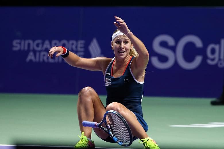 Overcome by emotion, Dominika Cibulkova collapses on the court after her unexpected but decisive 6-3, 6-4 victory against Angelique Kerber in the WTA Finals at the Singapore Indoor Stadium yesterday.