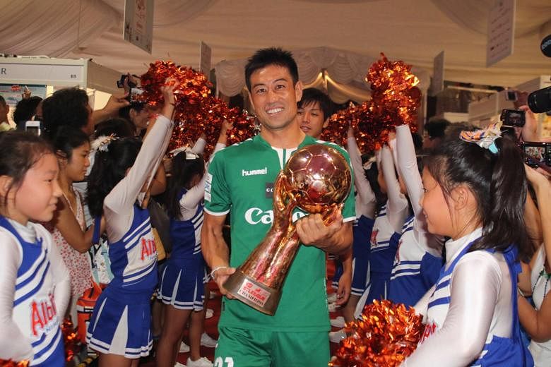 Albirex Niigata's captain Yosuke Nozawa showing off the S-League trophy as his team, including their top league scorer with 13 goals, Atsushi Kawata (behind), were welcomed by cheerleaders at the SJ50 Matsuri yesterday. At the two-day event to mark 5
