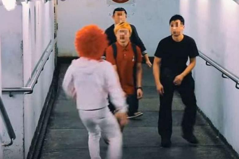A screenshot from the video showing a man in a clown outfit trying to scare passers-by.