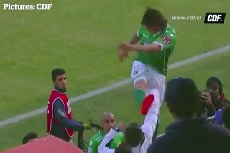A screen capture of Argentinian forward Sebastian Pol, from Chilean top-flight side Audax Italiano, kicking the fan, Cristobal Aztorquiza, after climbing the fence around the pitch.