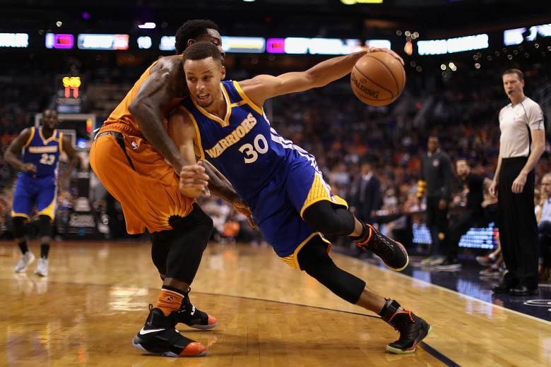 Golden State guard Stephen Curry trying to slash past Eric Bledsoe of the Phoenix Suns en route to the basket in a 106-100 victory on Sunday.