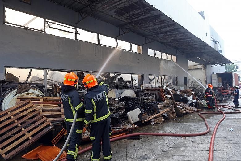Firefighters putting out the blaze at the three-storey warehouse leased by furniture dealer Winter International Group at 65 Sungei Kadut Loop yesterday morning. The SCDF said it was alerted to the fire at about 5am and found three people trapped on 