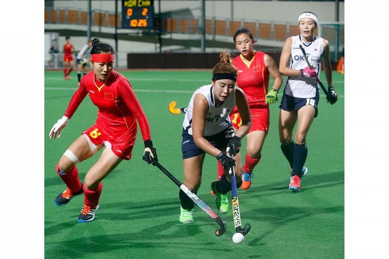China's Zhou Yu (left) trying to take the ball off South Korea's Park Ki Ju during the match at the Women's Asian Champions Trophy in Sengkang yesterday. China won 2-0.