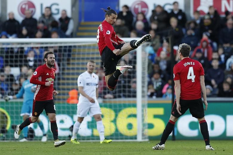 Zlatan Ibrahimovic letting fly with a karate kick a la ex-Manchester United legend Eric Cantona, as he celebrates scoring United's second goal - the striker's first in seven games - against Swansea with team-mate Phil Jones. Record signing Paul Pogba