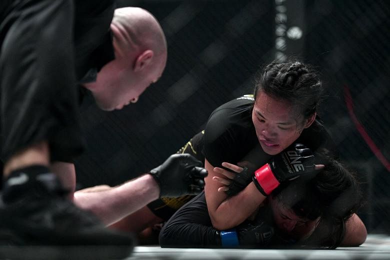 Tiffany Teo (top) grappling with Egyptian Walaa Abbas during their One Championship: Defending Honour flyweight bout at the Singapore Indoor Stadium last night. The Singaporean won after Abbas tapped out to a rear-naked choke at 4min 15sec in the sec