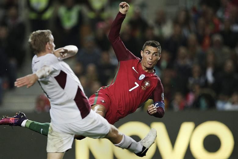 Cristiano Ronaldo (right) scoring Portugal's third goal in the 4-1 win against Latvia in the World Cup qualifying match at Algarve Stadium, Portugal, on Sunday.