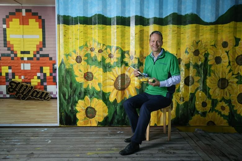 Mr Buchner, seated in front of the painted container walls at Ground-Up Initiative, a non-profit community-driven community in Yishun that believes in sustainable living and that has partnered AkzoNobel. Under Mr Buchner's charge, AkzoNobel went one 