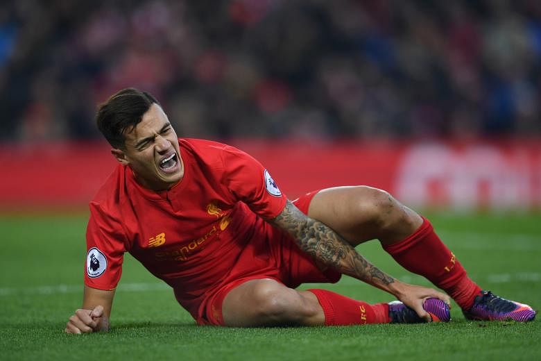 Liverpool midfielder Philippe Coutinho clutching his foot while lying injured on the pitch after a clash with Sunderland's Didier Ndong. The Brazilian may be ruled out of a crucial period of Liverpool's season.
