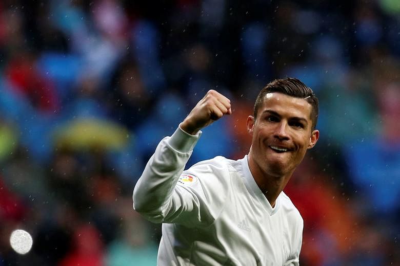 Cristiano Ronaldo celebrating one of his two goals against Sporting Gijon to help cement Real Madrid's position atop Spain's La Liga.