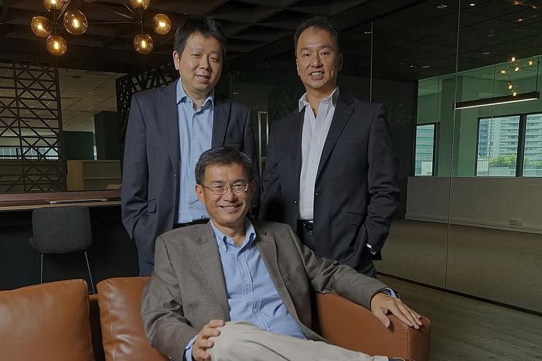 Spark Systems co-founder and chief executive Wong Joo Seng (seated) with chief technology officer Ye Ting Song (left) and chief operations officer Jason Wang Kee Huat. Spark Systems aims to eventually develop a Singapore-based foreign exchange market