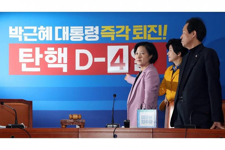 Ms Choo Mi Ae (far left), head of South Korea's main opposition Democratic Party, indicating a poster counting down to voting day on the motion to impeach President Park Geun Hye yesterday.