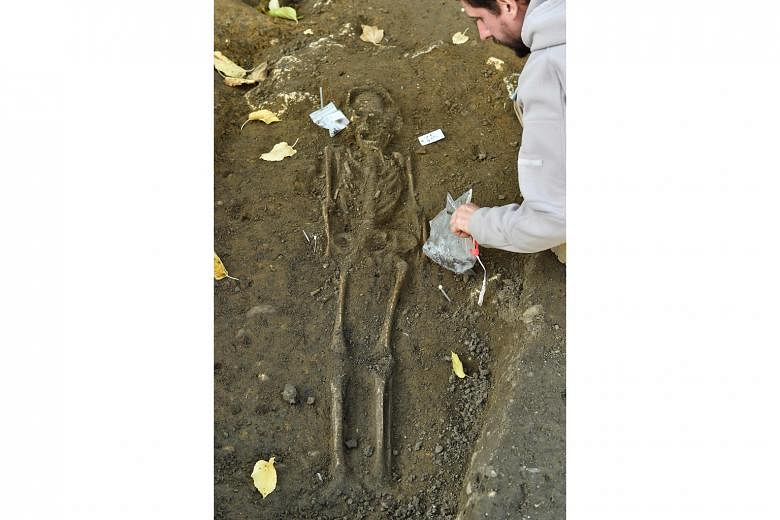 Mr Xavier Perrot, an archaeologist with the Office of Archaeological Investigation "Hades", excavating human bones on Tuesday in Bordeaux, France. An exceptional ancient necropolis, with more than 40 pits containing hundreds of skeletons, was discove