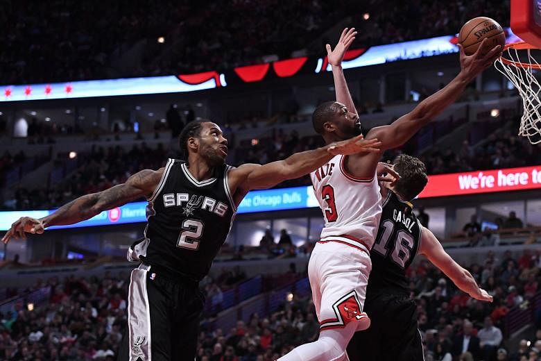Chicago Bulls guard Dwyane Wade going up for a basket, as San Antonio Spurs forward Kawhi Leonard and centre Pau Gasol fail to block him during the second half at United Centre. Chicago defeated San Antonio 95-91, falling one game short of tying Gold