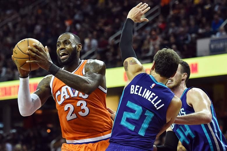 Cleveland Cavaliers forward LeBron James (left) looks to pass the ball against the Charlotte Hornets during the second half at Quicken Loans Arena. He had 44 points in the 116-105 win and became the first front-court player to complete 7,000 assists.