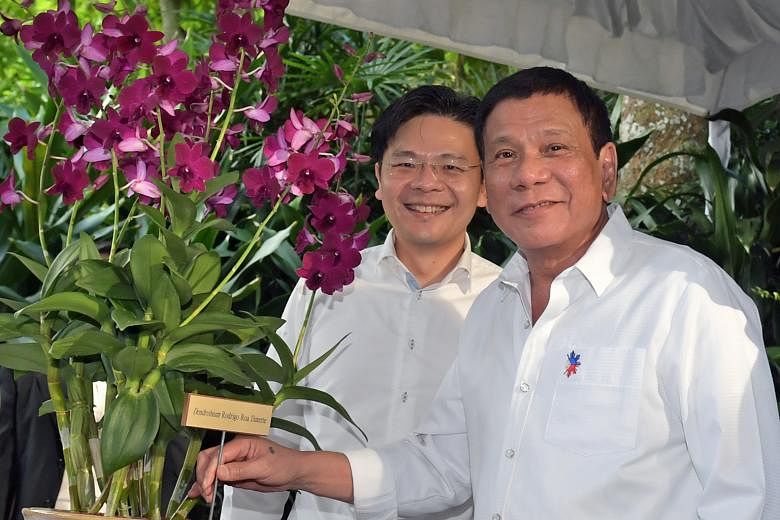 Left: Members of the Filipino community awaiting the arrival of Mr Duterte at the Singapore Expo yesterday. Many went with friends and family, while some had taken time off from work. Below: Mr Duterte earlier visited the Singapore Botanic Gardens, a