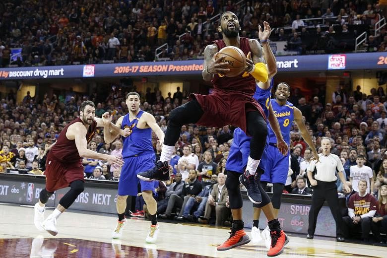 Cleveland guard Kyrie Irving going up for a shot after shrugging off the challenge of Golden State guard Stephen Curry, as Kevin Love (left), Klay Thompson and Draymond Green look on at the Quicken Loans Arena. Irving hit the winning jumper with 3.4 
