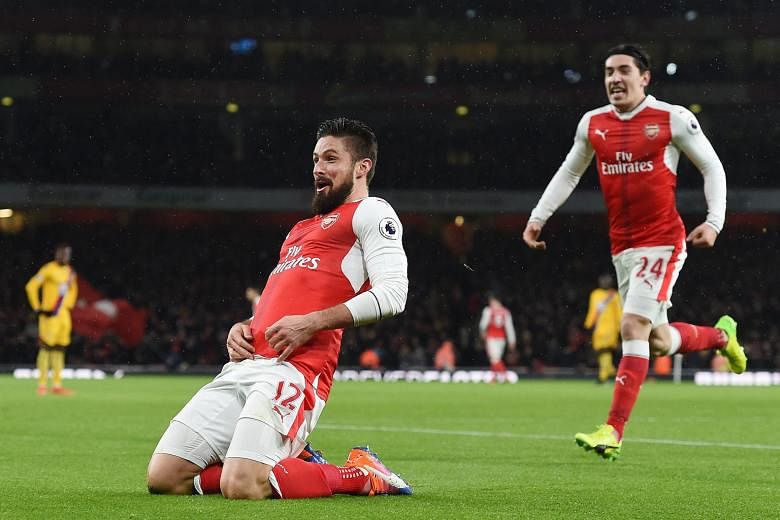 Olivier Giroud, who later said luck played a big part in his audacious goal, basks in the Arsenal fans' cheers as Hector Bellerin rushes to join in.