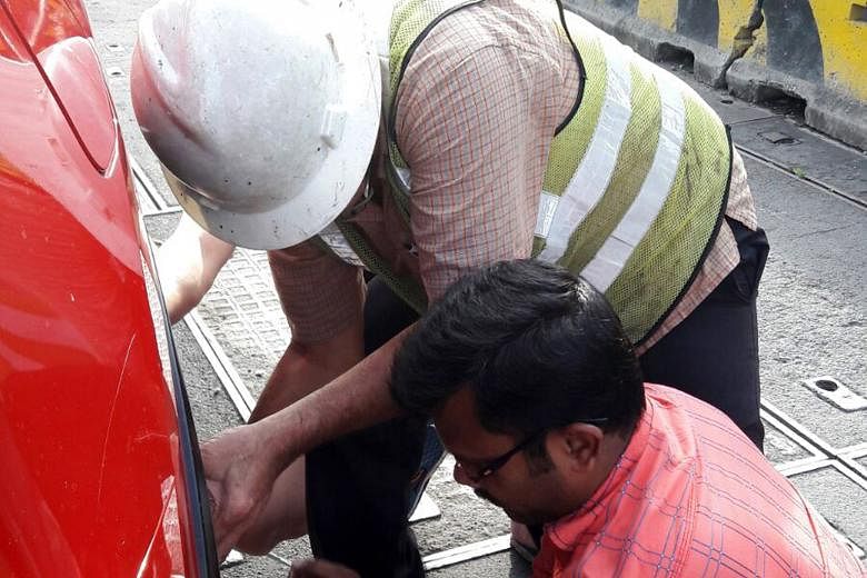 Mr Venkateswaran (in red), a lorry driver from India, was one of two people who helped to replace a motorist's car tyre on Wednesday.