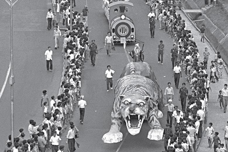Left: PA's Dr Ang (in red) and Mr Seow Choke Meng (fourth from left), business consultant of the Chinese Media Group and Times Properties of SPH, with Chingay performers at the book launch. Above: The Chingay Parade in 1974 featured a 9m-long tiger f