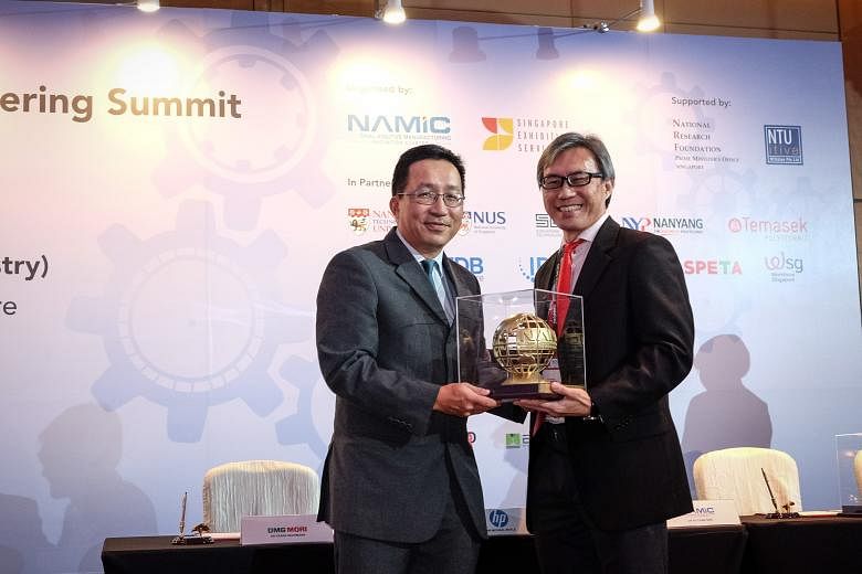 Mr Loh (left) receiving a token of appreciation, a 3D-printed metal globe emblazoned with Namic's logo, from Namic director Ho Chaw Sing at the opening of a summit on additive manufacturing yesterday.