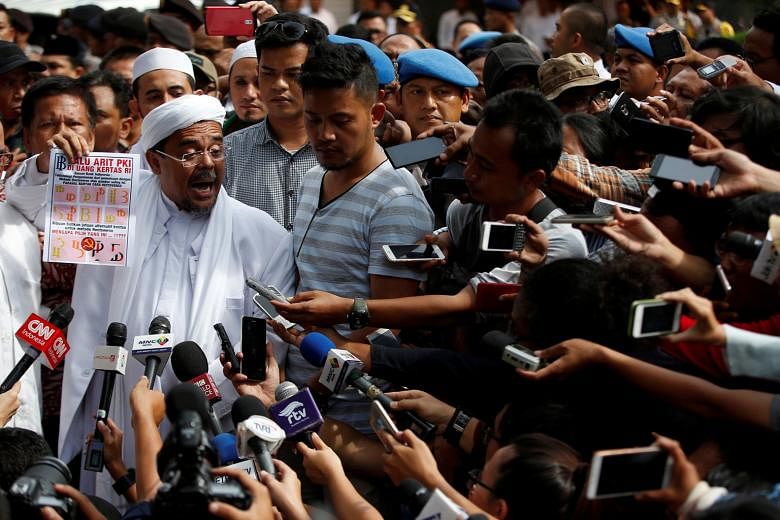 Cleric Habib Rizieq Shihab addressing reporters after being questioned by police for more than five hours yesterday. He wants the authorities to remove a hammer-and-sickle pattern in the new banknotes.