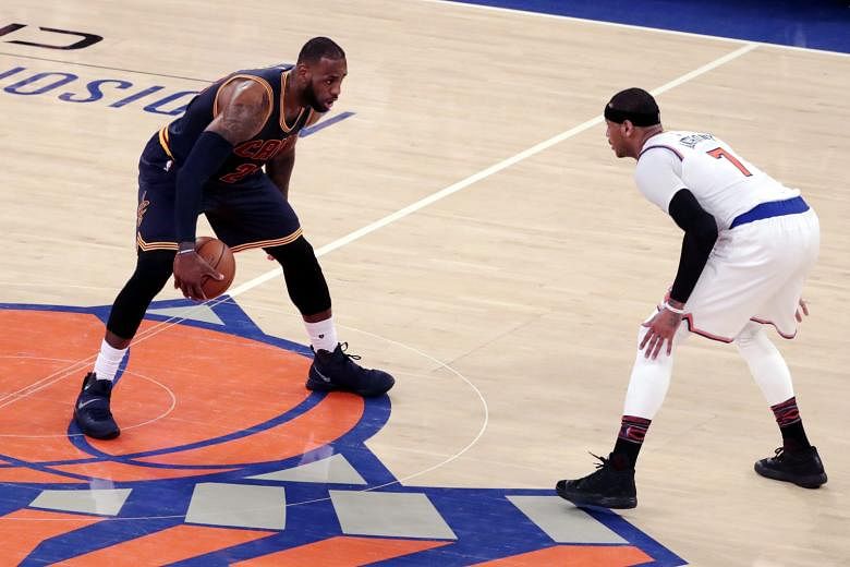 Cavaliers forward LeBron James coming up against Knicks forward Carmelo Anthony as he takes the ball up court.