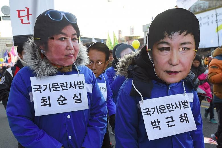 Protesters in masks of Ms Park (right) and her friend at a rally in December.