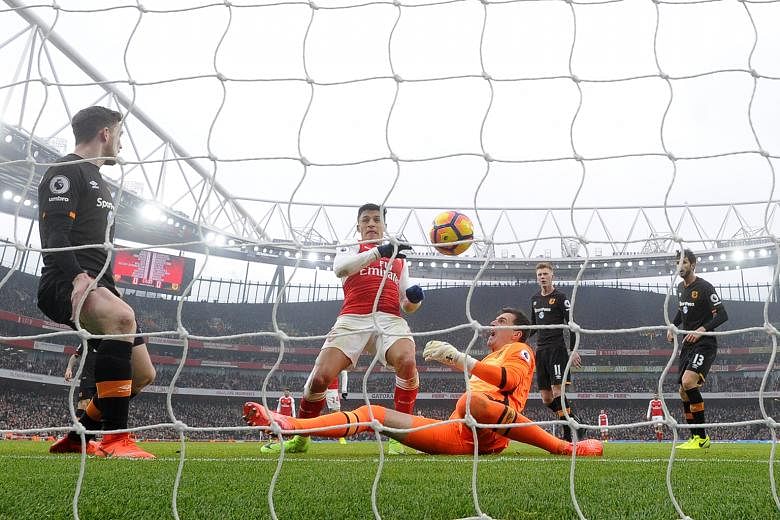 Hull goalkeeper Eldin Jakupovic is unable to prevent Arsenal's Alexis Sanchez from opening accounts at the Emirates Stadium. The goal was given despite the ball going in off the Chilean forward's right hand.