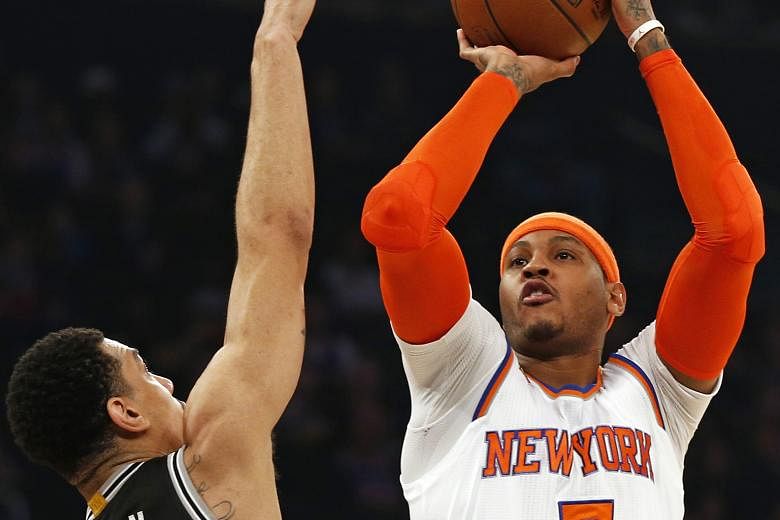 New York Knicks' Carmelo Anthony shooting over San Antonio Spurs' Danny Green. Anthony led his team in points, scoring 25 as New York beat San Antonio 94-90 in an unexpected victory.
