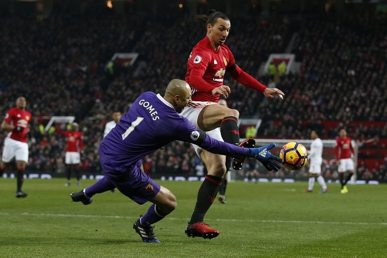 Manchester United striker Zlatan Ibrahimovic attempting to poke the ball away from Watford's Heurelho Gomes. The Swede, who is joint-third in the league's scoring standings with 15 goals, did not get on the scoresheet as United won 2-0.