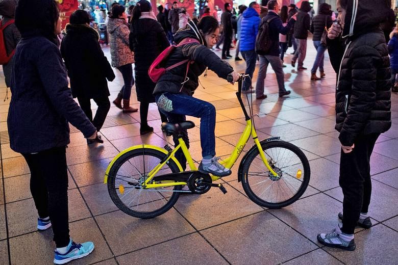 A girl riding an Ofo bicycle in Shanghai. After meeting with Shanghai officials, operators of Mobike, Ofo and Bluegogo promised to revamp equipment and security procedures to block underage users from accessing their bikes.