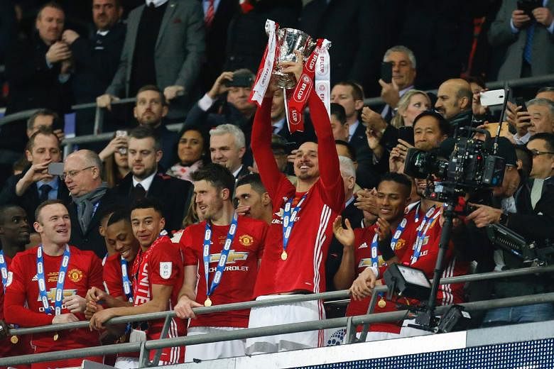 Man-of-the-Match Zlatan Ibrahimovic lifting the trophy as Manchester United players celebrate their League Cup final victory over Southampton at Wembley. The Swedish striker sealed the first major silverware of Jose Mourinho's Manchester United reign