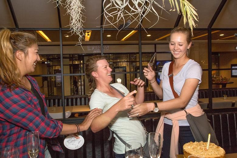 American golfers (from left) Alison Lee, Austin Ernst and Jessica Korda enjoying a surprise double birthday celebration for Lee (who turned 21 on Sunday) and Korda (23 yesterday) at the Greyhound Cafe in Paragon shopping centre yesterday. The trio, t