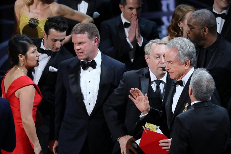 PricewaterhouseCoopers accountants Martha L. Ruiz (left) and Brian Cullinan (third from left) conferring on stage after the Best Picture statuette was mistakenly awarded to La La Land instead of Moonlight. Mr Cullinan was said to have been tweeting b